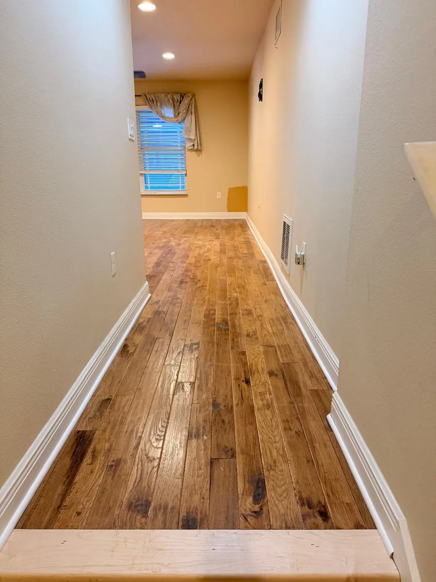 Hallway with newly installed hardwood flooring before sanding and staining