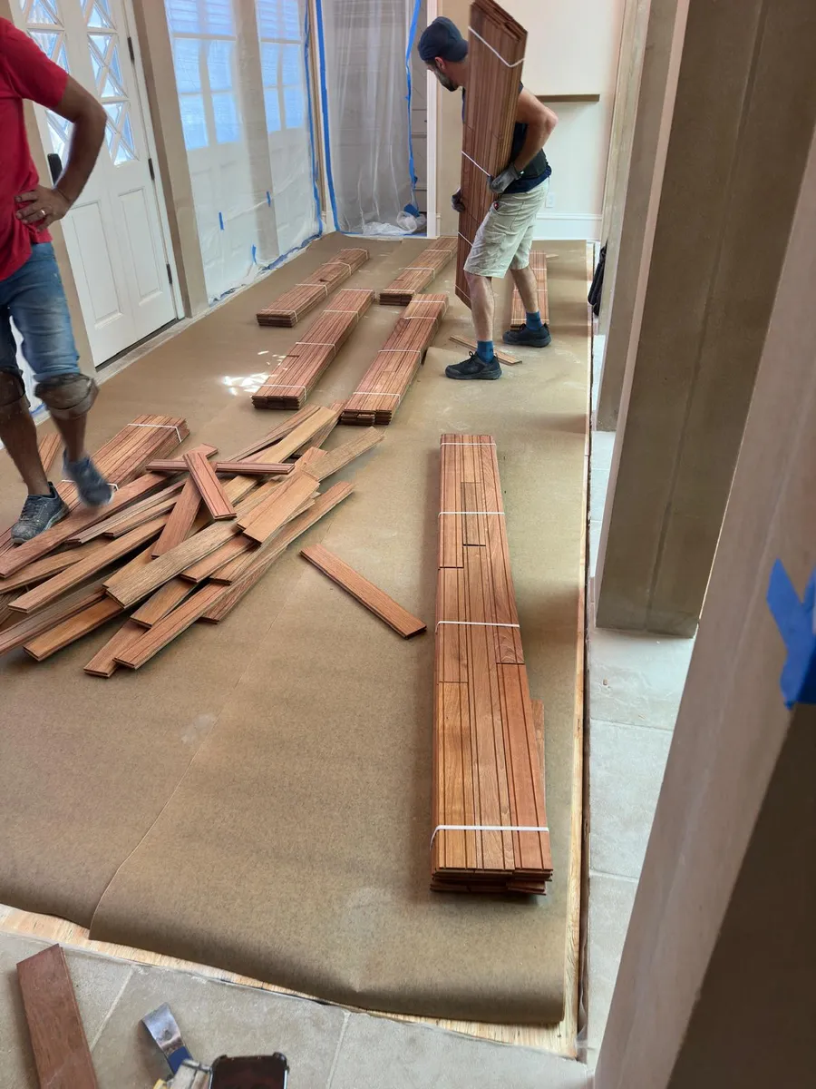 Installers laying new hardwood flooring planks