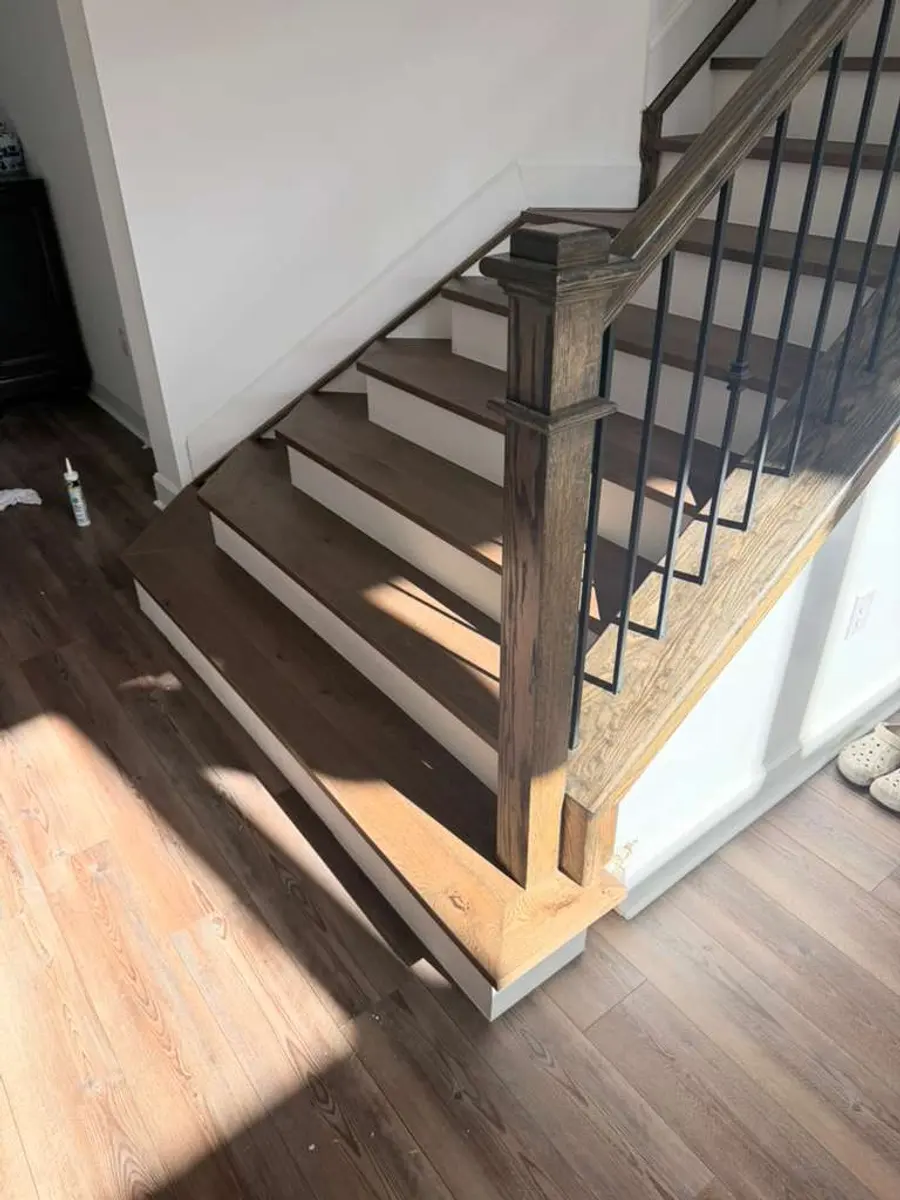 Staircase with dark wood treads and iron railing