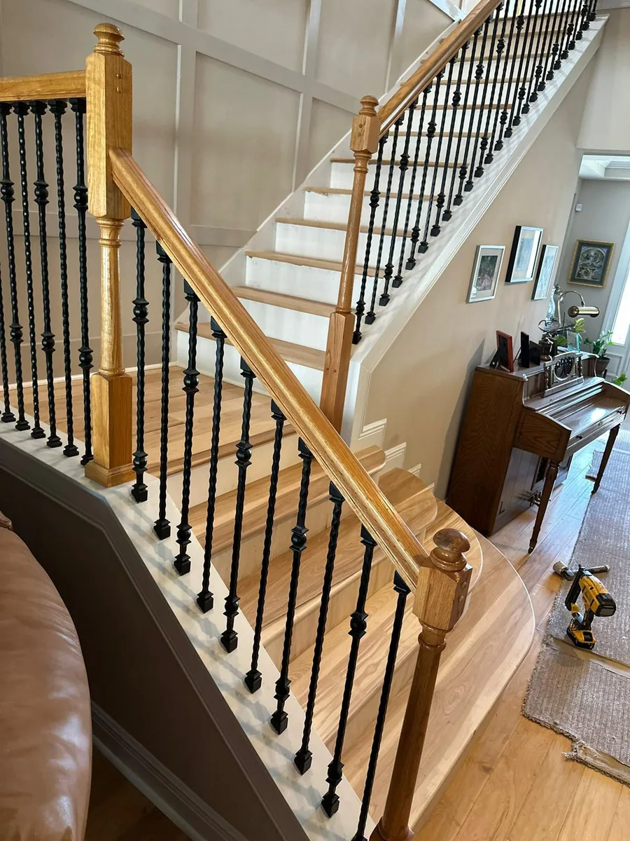 Aerial view of a curved staircase with light oak-tone treads